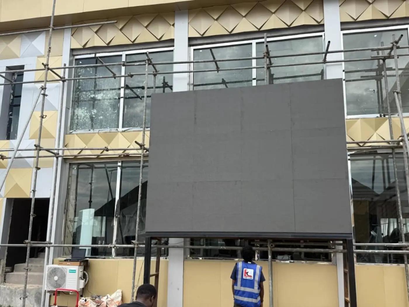 Veraji team installing a digital LED billboard on a building facade in Abuja